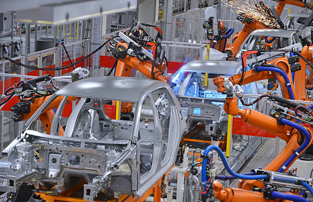 robots welding in factory robots welding in an automobile factory production line stock pictures, royalty-free photos & images