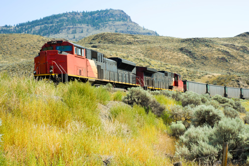 A freight train passes through the hillside of Kamloops, British Columbia, Canada.