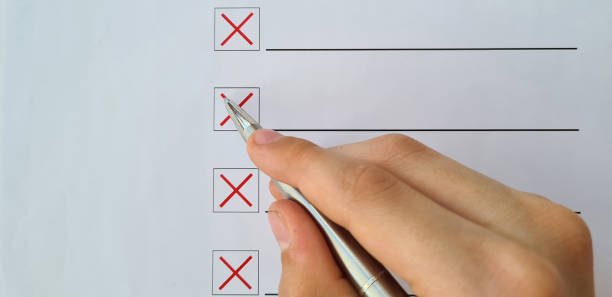 istock Student hand holds pen to complete test, makes crosses on optical form 1566486414
