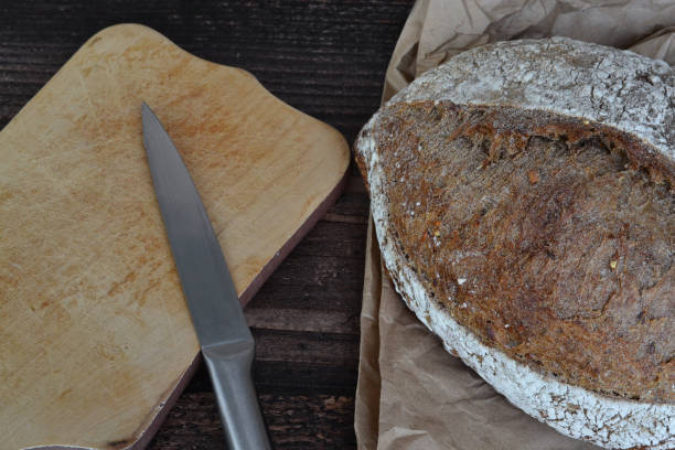 istock on a dark table lies bread and a wooden board with a knife 1566489623
