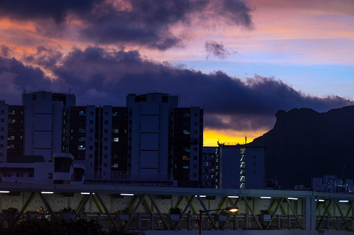 Kowloon famous landmark Lion rock mountain is located at the right hand-side and public housing in the left hand-side, with the background of sunset