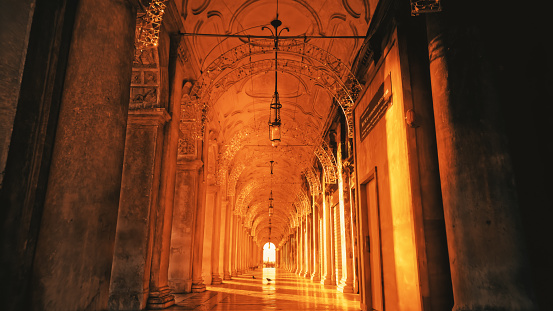 Archway aisle of Campanile tower at St. Mark's square during sunset