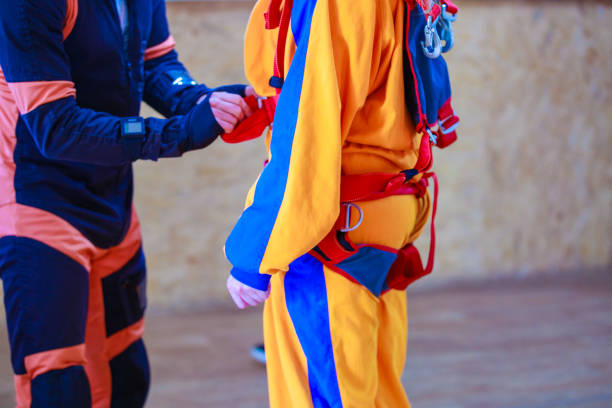 The instructor tightens the straps of the parachute suit. The instructor tightens the straps of the parachute suit. High quality photo skydiving stock pictures, royalty-free photos & images