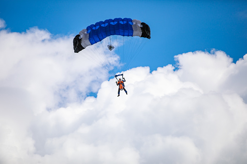 Low angle view of two people doing tandem paragliding high up