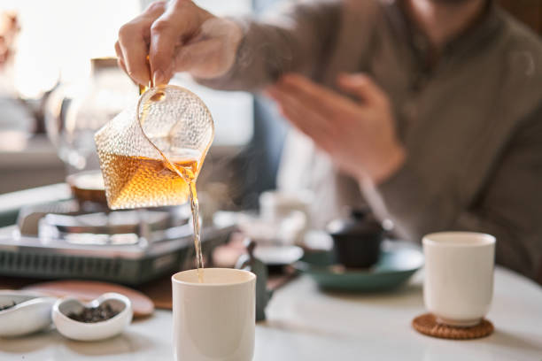 istock Tea master pours white tea to guests. Everything is ready for the tea ceremony. The ceremony is according to all the rules, but not in the classical style. Adapted to a modern apartment. 1566572883