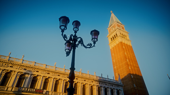 Street lamp by Campanile tower at St. Mark's square against clear sky on sunny day
