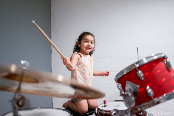 istock Cute Hispanic Little girl playing drums 1566577851