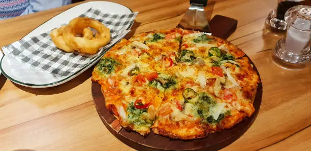 Pizza and Onion Rings served in a restaurant on Patong Beach, Phuket, Thailand