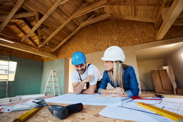 istock Happy inspector and manual worker examining plans at construction site. 1566587026