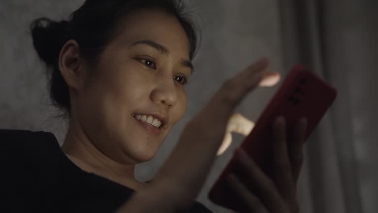 Beautiful Asian woman with phone addiction playing with her phone