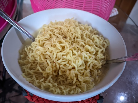 Closeup of a bowl of chicken broth-flavored instant noodles