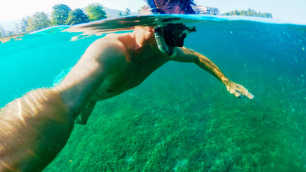 istock Man with swimming mask taking selfie while snorkeling in sea 1566603099