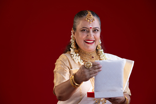 Traditional Indian woman in sari holding jewelry box in hands