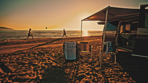캠핑카 밖 해변에서 배구를 하는 커플 - outdoor chair beach chair sarong 뉴스 사진 이미지