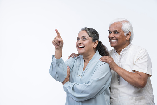 Portrait of loving senior couple over white background