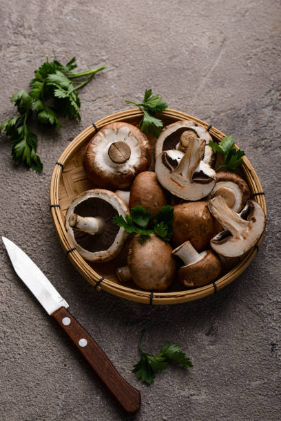 istock Raw champignon mushrooms on black background 1566686940