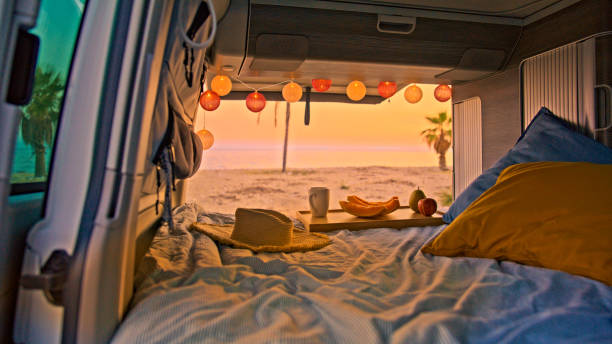 istock Fruits and coffee cup on bed in campervan at the beach 1566695554