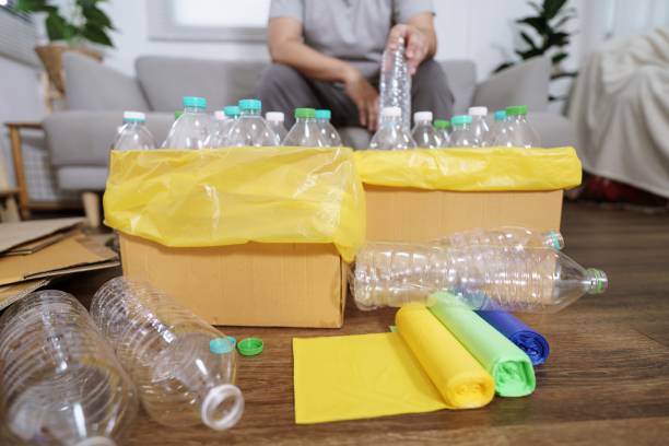 istock Home recycle eco green zero concept Man throwing empty plastic bottle in recycling bin with yellow garbage bags at home 1566706991