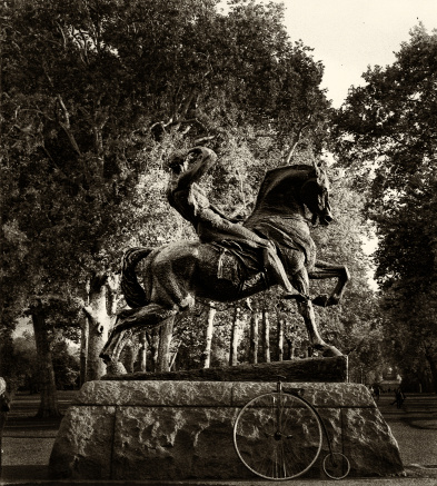 The Physical Energy statue at Kensington Gardens in London, England, viewed from the rear, with another means of exerting physical energy, the bicycle resting on its base.