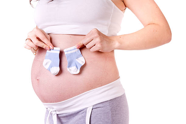 istock Baby socks on pregnant belly 156672124