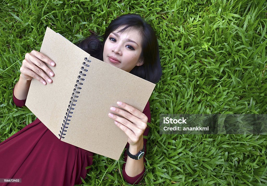 여자 라잉 녹색 잔디, 책 - 로열티 프리 공부 스톡 사진