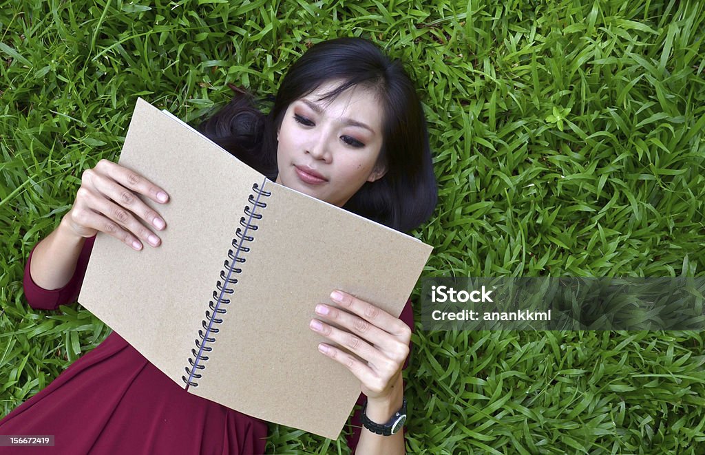 여자 라잉 녹색 잔디, 책 - 로열티 프리 공부 스톡 사진