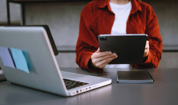 istock Businessman using mobile phone, tablet. and laptop Closeup on blurred background 1566738465