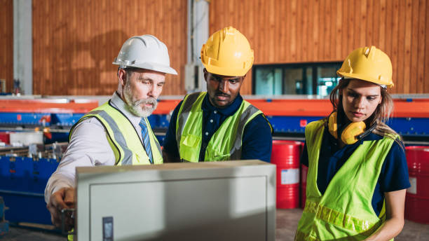 istock Industrial worker inspecting and check up machine at factory machines. Technician working in metal sheet at industry. Foreman checking Material or Machine. 1566739004