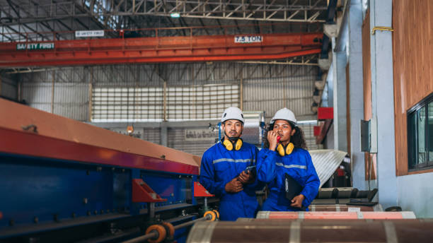 istock Industrial worker inspecting and check up machine at factory machines. Technician working in metal sheet at industry. Foreman checking Material or Machine. 1566743337