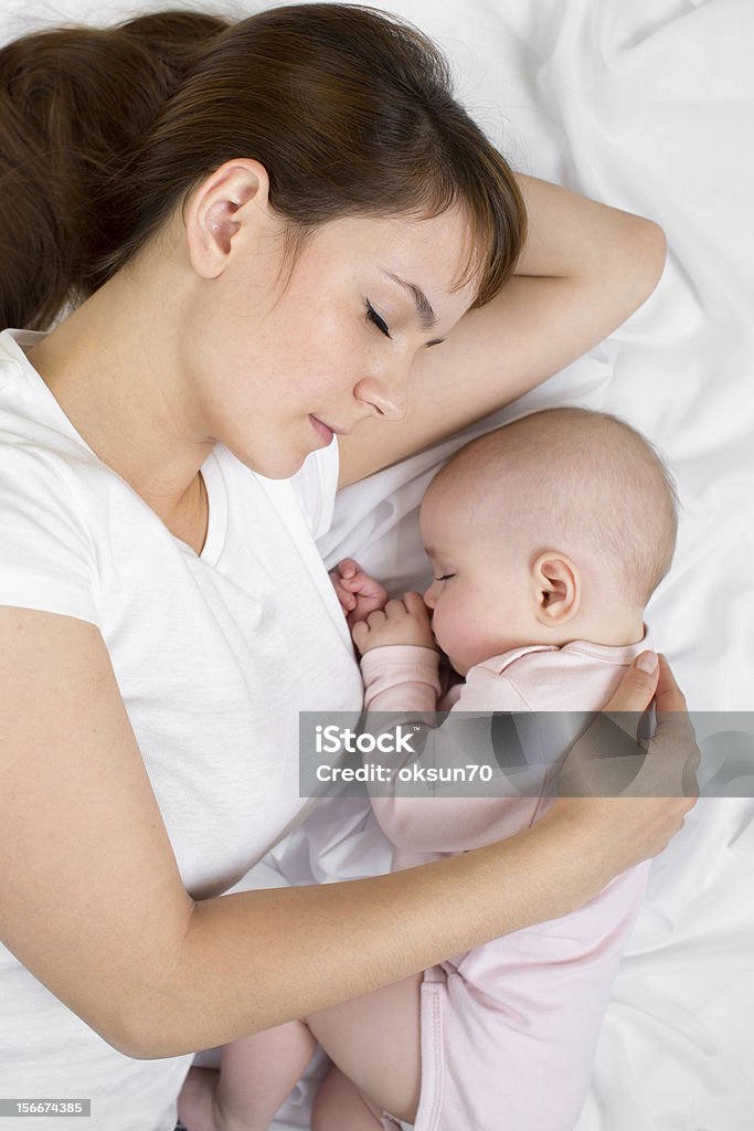 Young mother and her baby sleeping together 6-11 Months Stock Photo