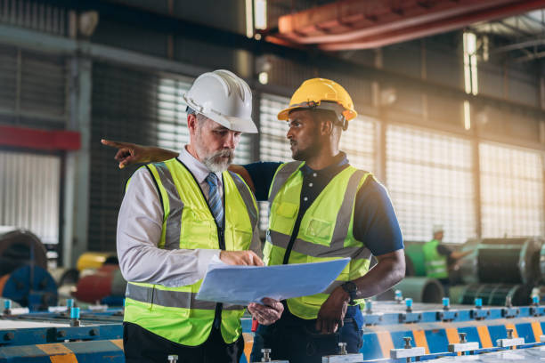 istock Industrial worker inspecting and check up machine at factory machines. Technician working in metal sheet at industry. Foreman checking Material or Machine. 1566745481