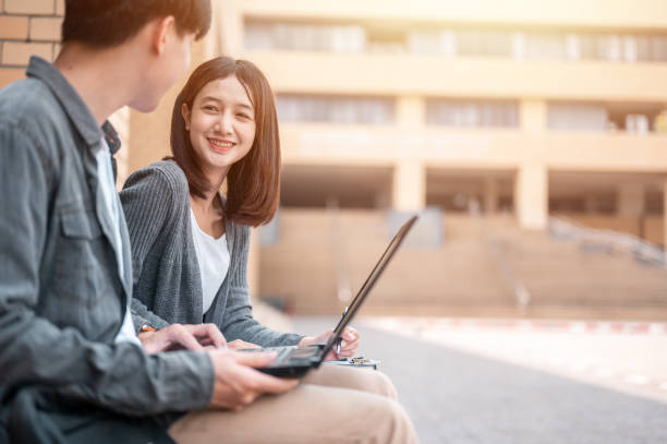 istock Portrait of the two students are using laptop discussing about exam preparation, study, study for test preparation in University. 1566750432