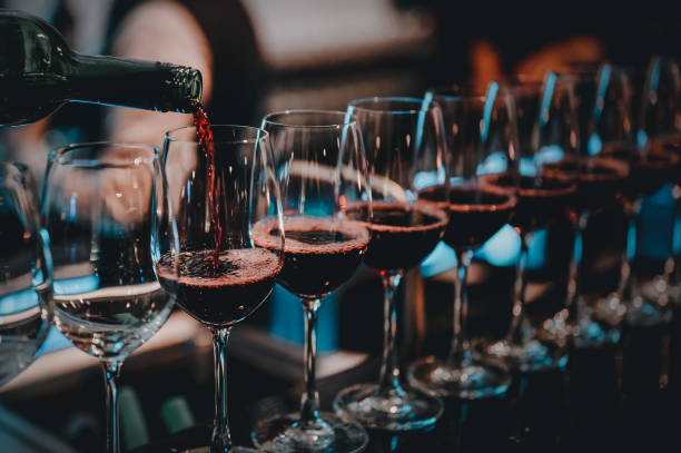 バーテンダーはバーでグラスに赤ワインを注ぎます。長い茎のワイングラスに赤ワインを注ぐ男性ソムリエ。 - thailand restaurant cocktail bar ストックフォトと画像
