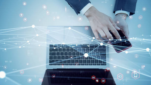 istock businessperson using a laptop PC and a smart phone. Communication network. 1566768197