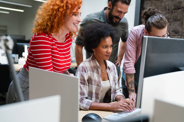 istock Diverse group of professionals meeting in office. IT programmers use computer, talk strategy 1566771574