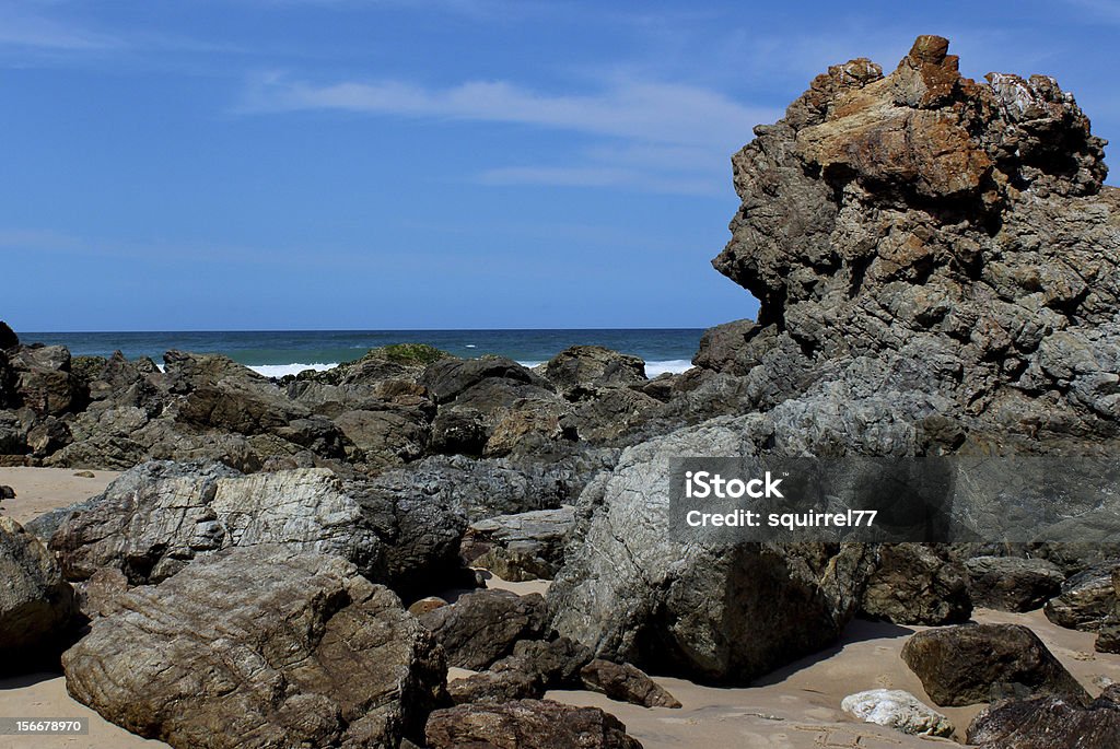 Playa de rocas contra el cielo azul - Foto de stock de Agua libre de derechos