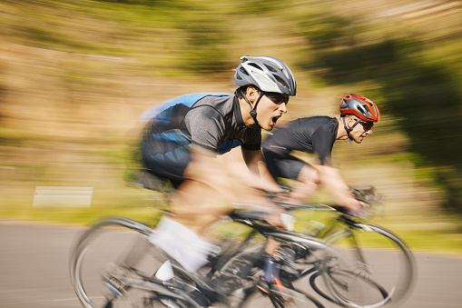 Man, mountain and cycling in motion blur, speed and helmet for training together, exercise and health in summer. Cyclist athlete, teamwork and fast for race, performance and workout with competition