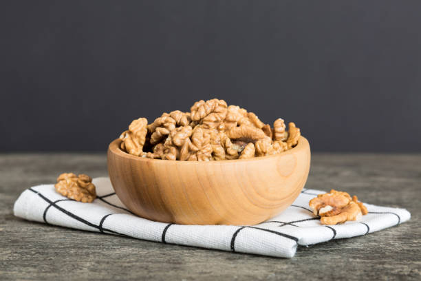 istock Fresh healthy walnuts in bowl on colored table background. Top view Healthy eating bertholletia concept. Super foods 1566793863