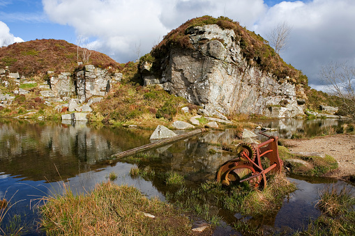 The flooded remains of the 19th century Haytor Quarry, in production between 1820 and 1850. Haytor Quarry is one of a number of disused quarries and is located on the northeastern side of Dartmoor National Park. Granite from this quarry was used for many important building projects around the country, including the British Museum, the General Post Office and London Bridge.