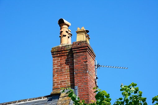 Traditional red brick chimneys atop a building along the High Street, Chard, Somerset, UK, Europe
