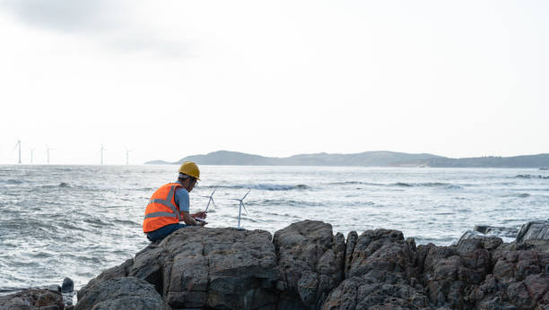 istock Wind farm engineers work by the sea 1566813057