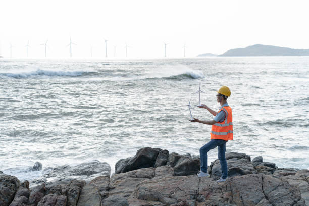 istock Male technician at a wind farm working by the sea 1566814175