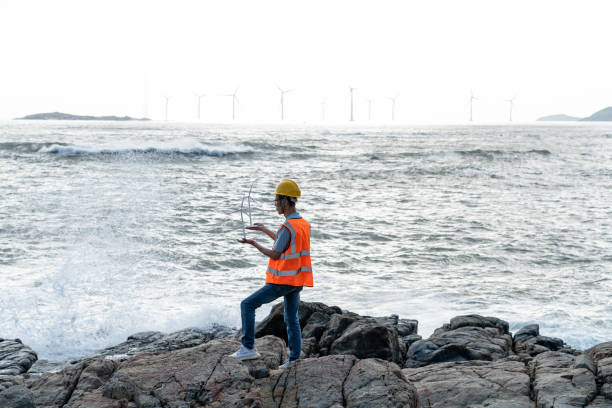 istock Wind farm technicians working by the sea 1566814180