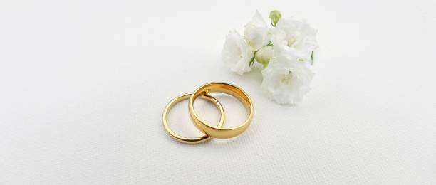 istock Wedding invitation with gold rings and small flower 1566824012