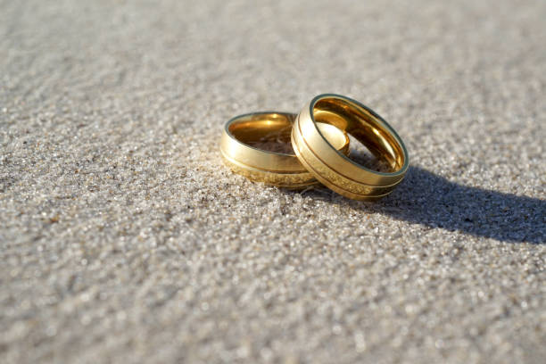 istock Wedding rings at the beach with copy space 1566826682