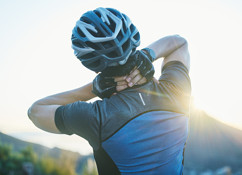 Man, cycling and neck pain with injury outdoor, stress and helmet for safety, fitness or exercise in sunshine. Cyclist, emergency and medical problem in countryside for workout, race or performance
