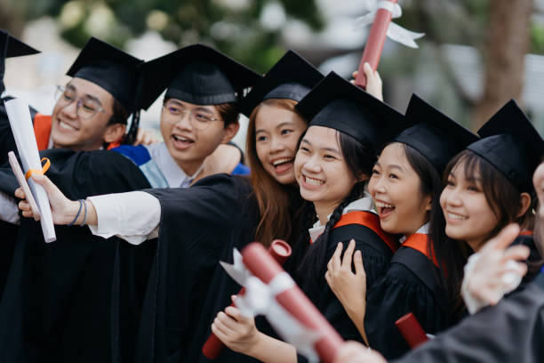 卒業式後に歓声を上げるアジアの大学生 - scroll content ストックフォトと画像