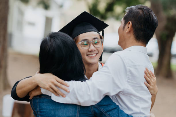 istock Young asian graduate student hugging his parents 1566847322