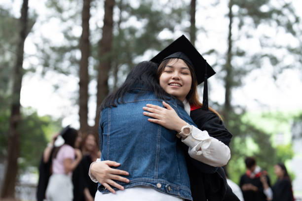 istock Young asian graduate student hugging her mother 1566847505