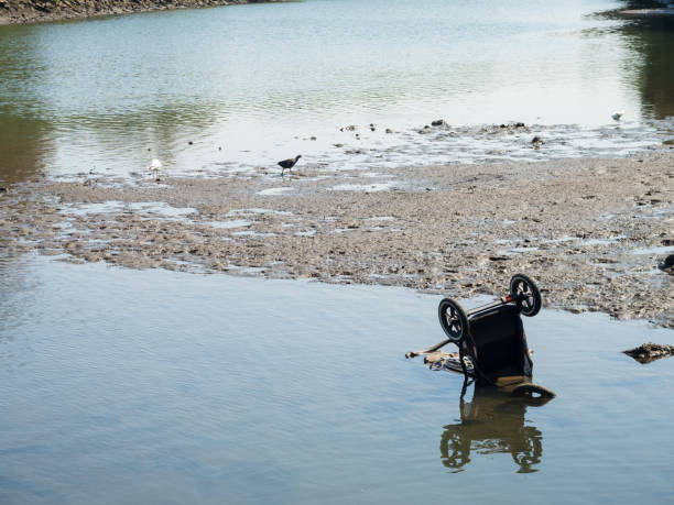 istock Old dumped Baby Pram on the riverbed at low tide. 1566854860